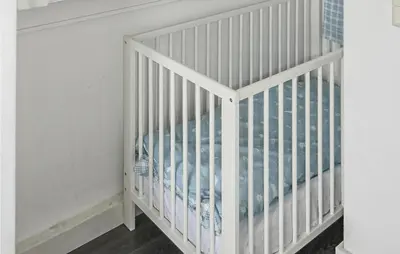 a white crib in a room with white walls at Awesome Apartment In Bergen An Zee in Bergen aan Zee