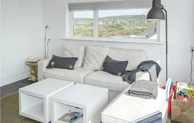 a living room with a white couch and a window at Awesome Apartment In Bergen An Zee in Bergen aan Zee