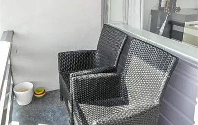 a black wicker chair sitting next to a window at Awesome Apartment In Bergen An Zee in Bergen aan Zee