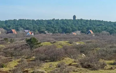 a group of houses and a lighthouse on a hill at Awesome Apartment In Bergen An Zee in Bergen aan Zee
