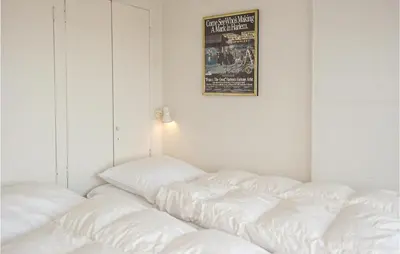 a room with white pillows and a picture on the wall at Zeebalkon in Bergen aan Zee