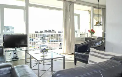 a living room with a couch and a tv and a table at Zeebalkon in Bergen aan Zee