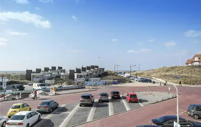 a parking lot with cars parked in front of a building at Zeebalkon in Bergen aan Zee