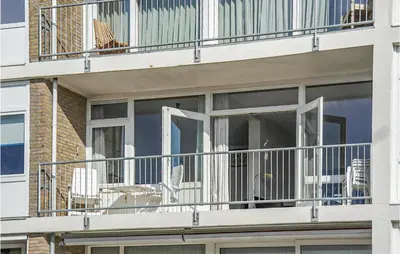 a balcony with chairs and tables on a building at Zeebalkon in Bergen aan Zee