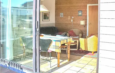 a screened in porch with a table and a couch at Pimpernel1 in Bergen aan Zee