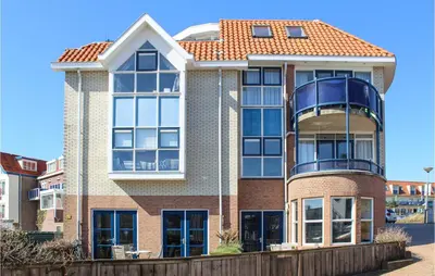 a large brick building with a red roof at The Blue Whale in Bergen aan Zee