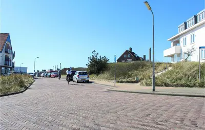 a person riding a bike down a brick road at The Blue Whale in Bergen aan Zee