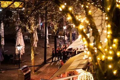 a group of people walking around a street with lights at Mylos Studios in Alkmaar