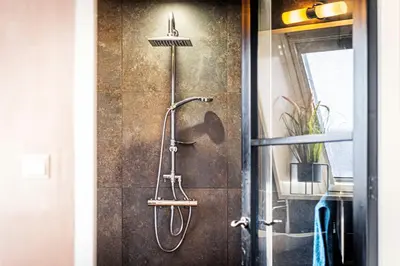 a shower in a bathroom next to a door at Mylos Studios in Alkmaar
