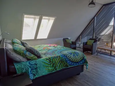a bedroom with a bed with a colorful comforter at Bed & Breakfast De Leekerhoek in Oosterleek