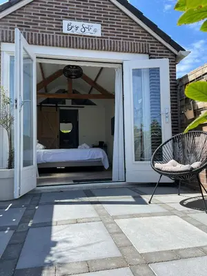 a bedroom with a bed inside of a glass door at Be So Suite in Zandvoort