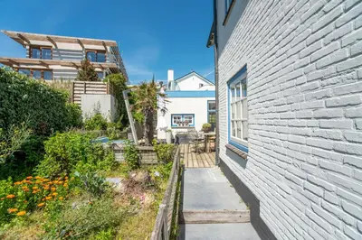 a brick building with a sidewalk next to a yard at Family Villa behind the Beach in Zandvoort