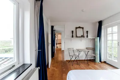 a bedroom with a table and chairs in a room at Family Villa behind the Beach in Zandvoort