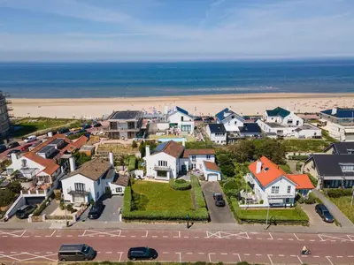 an aerial view of a residential neighborhood with the beach at Family Villa behind the Beach in Zandvoort