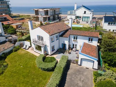 an aerial view of a house with the ocean in the background at Family Villa behind the Beach in Zandvoort
