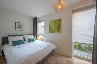 a bedroom with a bed and a large window at Meerzicht 20 - Waanzinnig uitzicht over het water! in Uitgeest