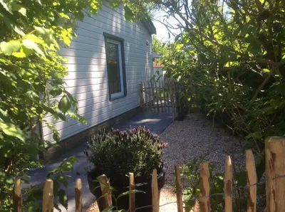 a garden in front of a house with a fence at Klein geluk in Warmenhuizen