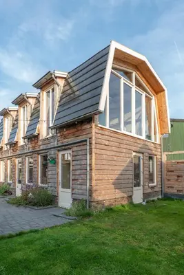 a wooden house with solar panels on top of it at klein polderhuis - bollenschuur in Roelofarendsveen