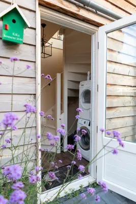 a front door of a house with a washing machine at klein polderhuis - bollenschuur in Roelofarendsveen