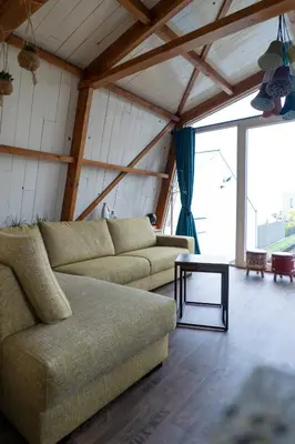 a living room with a couch and a table at klein polderhuis - bollenschuur in Roelofarendsveen