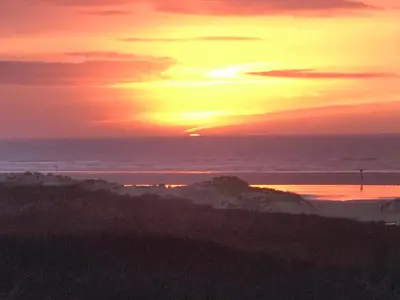 a sunset over the ocean with the sun setting at Chalet Formentera in de duinen van IJmuiden aan Zee in IJmuiden