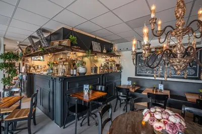 a dining room with tables and a bar at Chalet Formentera in de duinen van IJmuiden aan Zee in IJmuiden