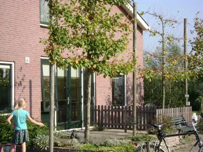 a girl is standing in front of a house at Boerderij Hazenveld in Kockengen