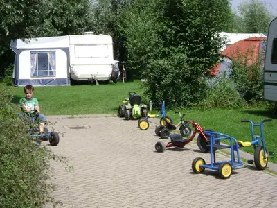 a group of children playing with toy cars in a yard at Boerderij Hazenveld in Kockengen