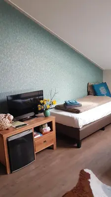 a bedroom with a bed and a tv and a table at Boerderij Hazenveld in Kockengen
