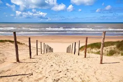 a wooden fence on a beach near the ocean at Romana in Zandvoort