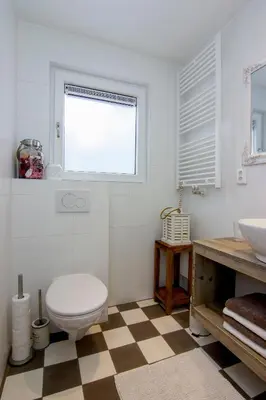a bathroom with a toilet and a sink and a window at Romana in Zandvoort