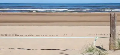 a bench on a beach with the ocean in the background at Romana in Zandvoort
