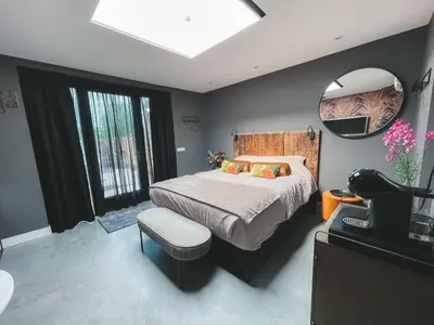 a bedroom with a bed and a mirror and a television at B&B Landslake I in Landsmeer