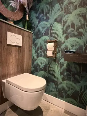 a bathroom with a toilet and a green leafy wallpaper at B&B Landslake I in Landsmeer