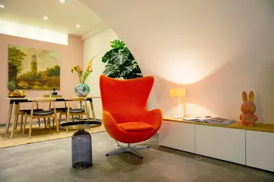 a living room with a orange chair and a table at LOFT 188 Luxury Apartment Hotel in Utrecht
