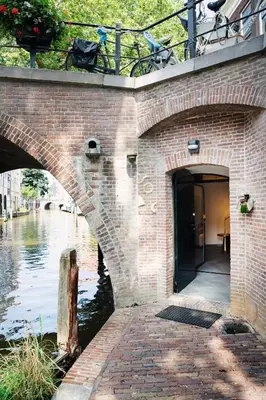 a brick building with a bridge over a river at LOFT 188 Luxury Apartment Hotel in Utrecht