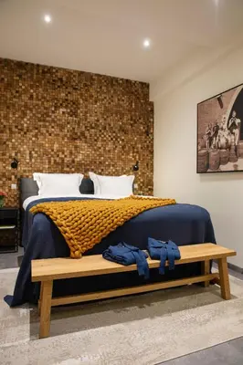 a bedroom with a bed and a brick wall at LOFT 188 Luxury Apartment Hotel in Utrecht