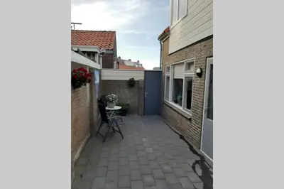 a patio with a table and a building at Zomerhuis Strand 28 in Egmond aan Zee