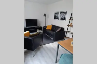 a living room with a couch and a tv at Zomerhuis Strand 28 in Egmond aan Zee