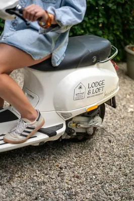 a woman is sitting on a scooter at LODGE & LOFT in Sassenheim