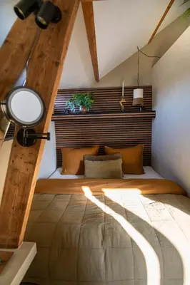 a bedroom with a bed with a wooden headboard at LODGE & LOFT in Sassenheim