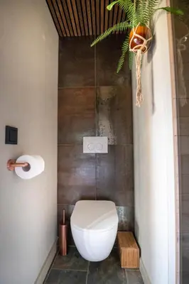 a bathroom with a toilet and a plant at LODGE & LOFT in Sassenheim
