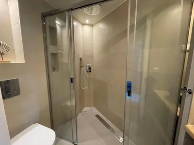 a bathroom with a glass shower with a toilet at Coconut Beach apartments in Zandvoort