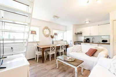 a living room with a white couch and a table at Küstenwind in Zandvoort