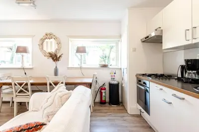 a kitchen and dining room with a couch and a table at Küstenwind in Zandvoort