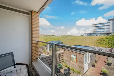 a balcony with a view of a building at Perfect Stay Holiday, Moment at Sea in Egmond aan Zee