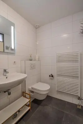 a white bathroom with a toilet and a sink at Perfect Stay Holiday, Moment at Sea in Egmond aan Zee