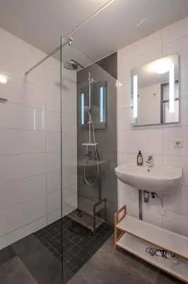 a bathroom with a sink and a glass shower at Perfect Stay Holiday, Moment at Sea in Egmond aan Zee