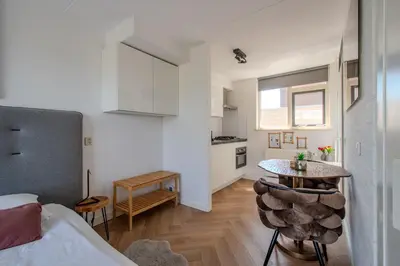 a room with a bed and a table and a kitchen at Perfect Stay Holiday, Moment at Sea in Egmond aan Zee