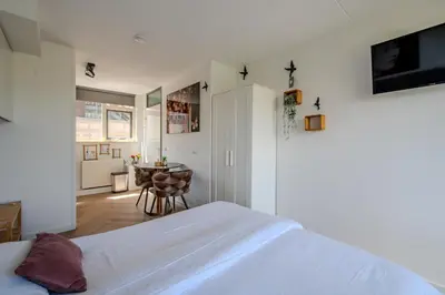 a bedroom with a white bed and a table at Perfect Stay Holiday, Moment at Sea in Egmond aan Zee